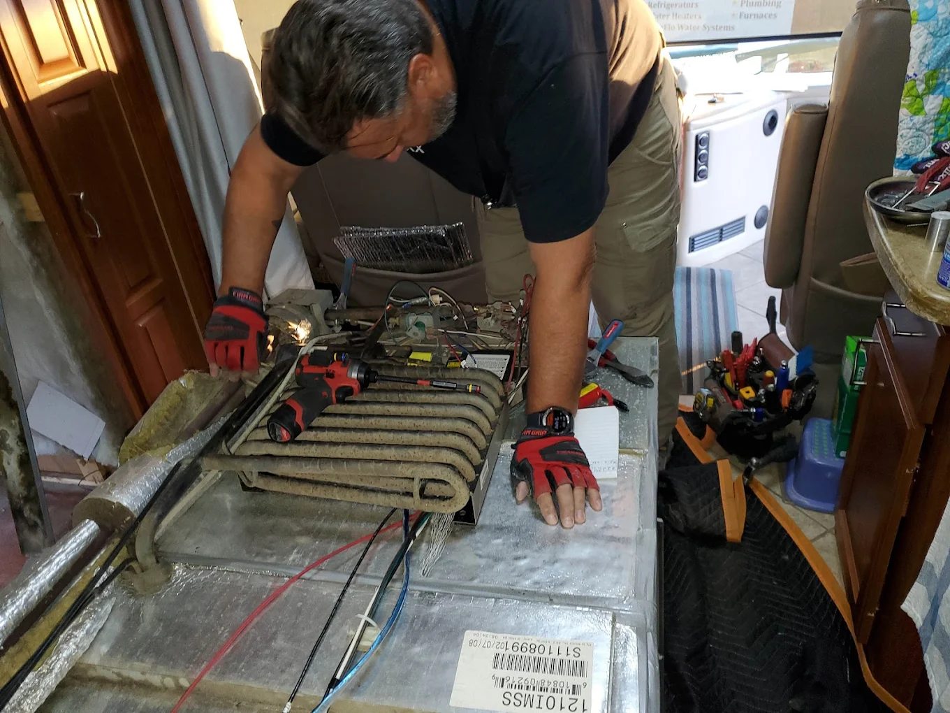 Technician working on RV refrigerator cooling unit