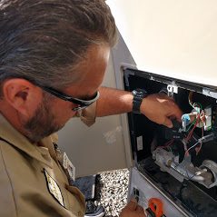 Technician inspecting RV water heater controls